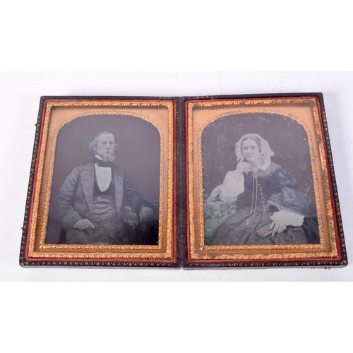 890 - A LEATHER BOUND CASED PAIR OF TINTED DAGUERREOTYPES OF A SEATED VICTORIAN GENTLEMAN AND HIS WIFE.  1... 