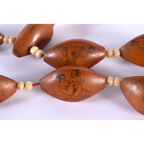 1543 - A RARE EARLY 20TH CENTURY CHINESE CARVED NUT AND BONE EROTIC NECKLACE decorated with figures in prom... 