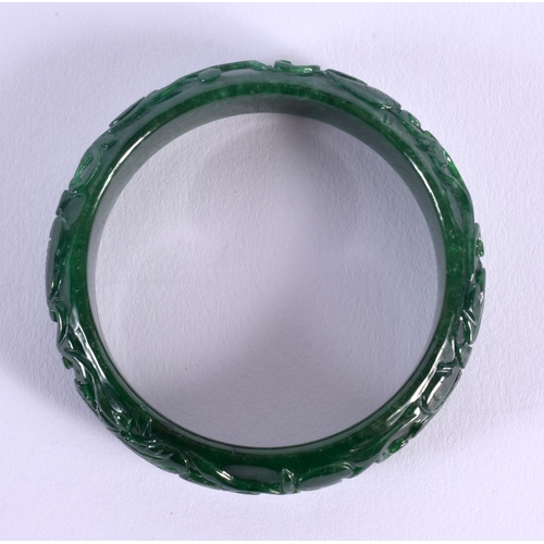 1659 - A CHINESE CARVED JADE BANGLE 20th Century. 7 cm diameter.