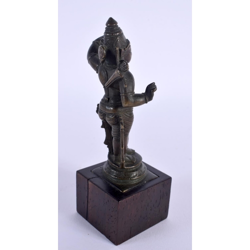 1699 - A 19TH CENTURY MIDDLE EASTERN INDIAN BRONZE DEITY upon a wooden plinth. 14 cm high.