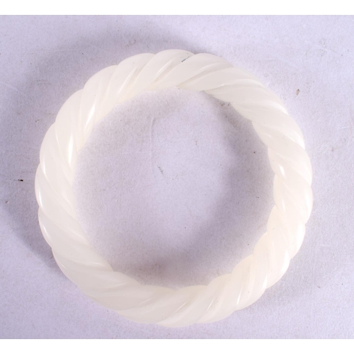 2096 - A CHINESE CARVED WHITE JADE TWIST BANGLE 20th Century. 6 cm diameter.