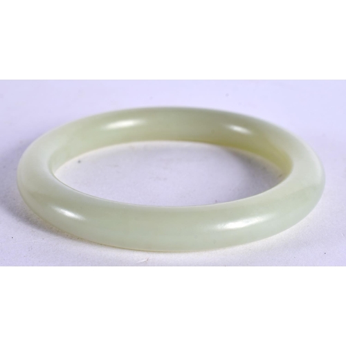 2206 - A CHINESE CARVED GREEN JADE BANGLE 20th Century. 5.5 cm diameter.