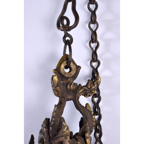 1867 - A RARE 19TH CENTURY INDIAN TIBETAN BRONZE HANGING BUDDHISTIC OIL BURNER formed with dragons and mask... 