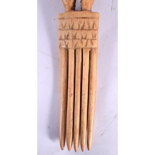 110 - A RARE 19TH CENTURY AFRICAN CARVED BONE TRIBAL COMB formed with a standing figure.18 cm long.