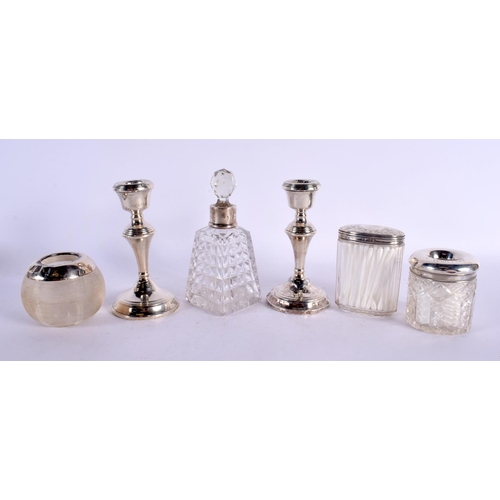 119 - THREE ANTIQUE SILVER TOPPED JARS together with a silver mounted scent bottle & a pair of silver cand... 