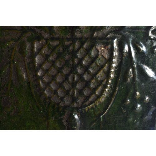 13 - AN EARLY DUTCH GREEN GLAZED POTTERY PANEL decorated with an urn of foliage and vines. 31 cm x 18 cm.