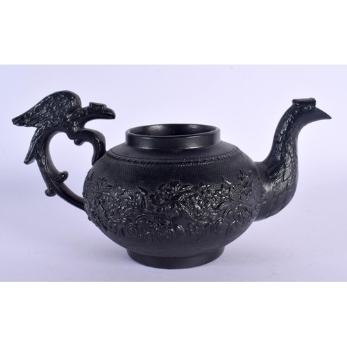 163 - AN EARLY 19TH CENTURY ENGLISH BLACK POTTERY TEAPOT decorated with foliage and vines. 17 cm wide.