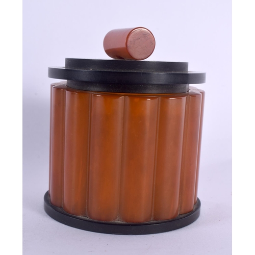 301 - AN ART DECO ORANGE BAKELITE CATALIN JAR AND COVER. 127 grams. 8 cm x 6.5 cm.