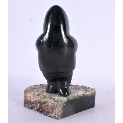 369 - A LOVELY NORTH AMERICAN INUIT CARVED JADE FIGURE OF A SEAL HUNTER modelled upon a naturalistic base.... 