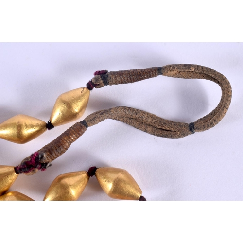 1543 - A 12TH / 13TH CENTURY CENTRAL ASIAN GOLD LEAF NECKLACE comprising 30 gold leaf covered beads, approx... 