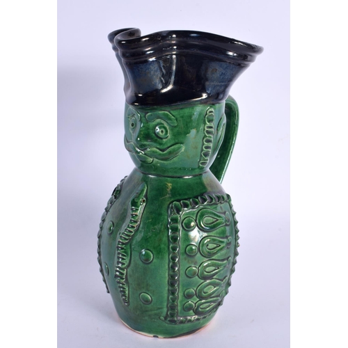 130 - AN UNUSUAL ANTIQUE GREEN GLAZED POTTERY CHARACTER JUG. 21 cm high.