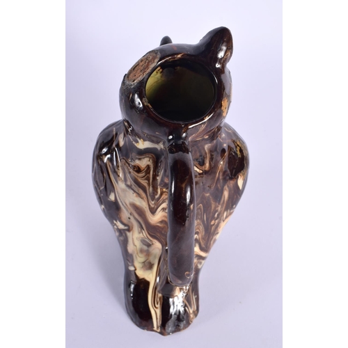 131 - A 19TH CENTURY TREACLE GLAZED POTTERY OWL JUG. 18 cm high.