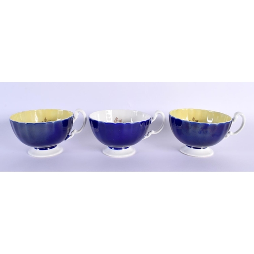 2 - A RARE SET OF THREE AYNSLEY BLUE AND YELLOW CUPS AND SAUCERS by Bailey, decorated with bold foliage.... 