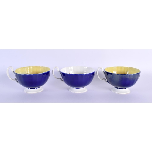 2 - A RARE SET OF THREE AYNSLEY BLUE AND YELLOW CUPS AND SAUCERS by Bailey, decorated with bold foliage.... 