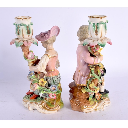 236 - DERBY PORCELAIN SEATED PAIR OF CANDLESTICK FIGURES, MODELLED AS A MAN WITH A HAT FILLED WITH FRUIT A... 