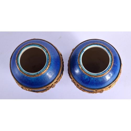 70 - AN UNUSUAL PAIR OF FRENCH SEVRES PORCELAIN BLUE VASES with gilt metal mounts. 8 cm high.