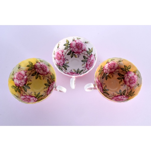 1 - A RARE SET OF THREE AYNSLEY PINK AND YELLOW PAINTED CUPS AND SAUCERS depicting bold roses. 13 cm dia... 