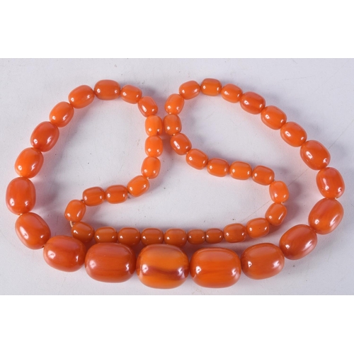 760E - AN AMBER NECKLACE.  Length 70cm, largest bead 21.1mm, weight 89g