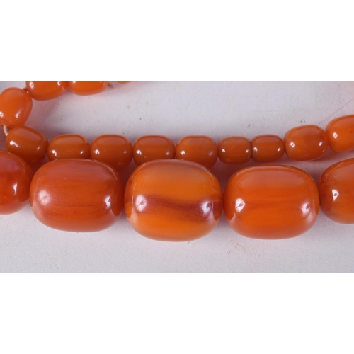 760E - AN AMBER NECKLACE.  Length 70cm, largest bead 21.1mm, weight 89g