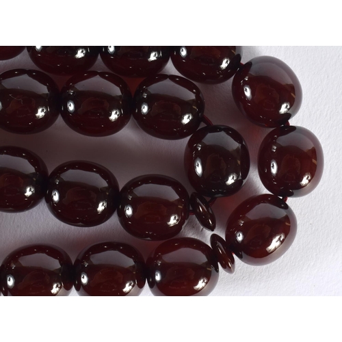 1642 - A STRING OF TURKISH RED AMBER TYPE PRAYER BEADS. 88 cm long.