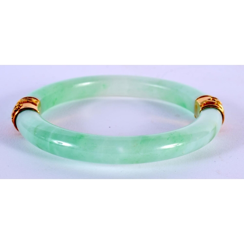 1704 - A GOOD 19TH CENTURY CHINESE JADEITE AND YELLOW METAL BANGLE. 85.4 grams. 7 cm internal diameter.