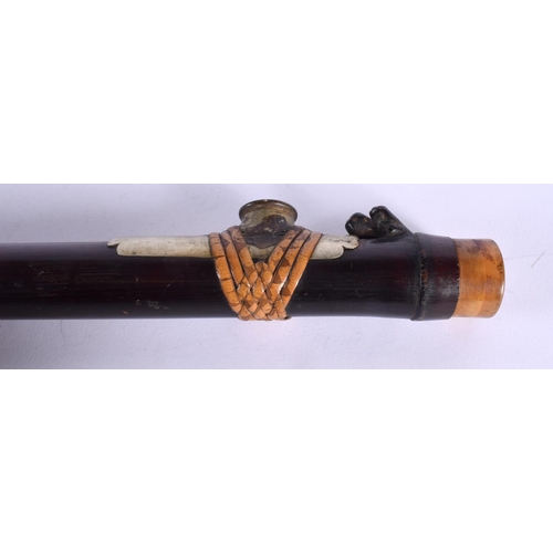 1921 - A 19TH CENTURY CHINESE CARVED RHINOCEROS HORN CAPPED OPIUM PIPE with lacquered body. 45 cm long.