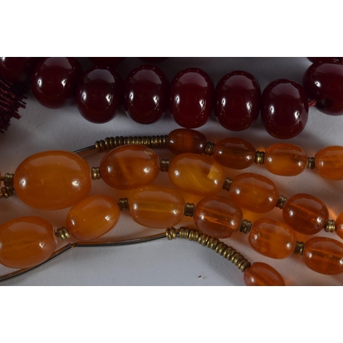 2013 - A CHERRY AMBER TYPE NECKLACE together with another. Largest 40 cm long. (2)