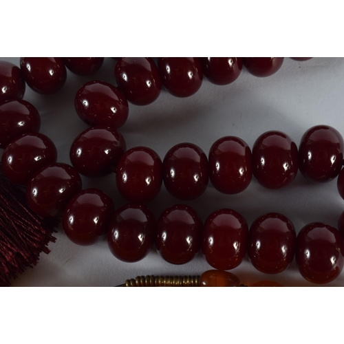 2013 - A CHERRY AMBER TYPE NECKLACE together with another. Largest 40 cm long. (2)