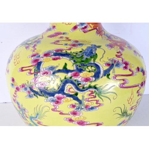 3118 - A huge Chinese porcelain yellow ground vase decorated in relief with Dragons and clouds. 56 cm