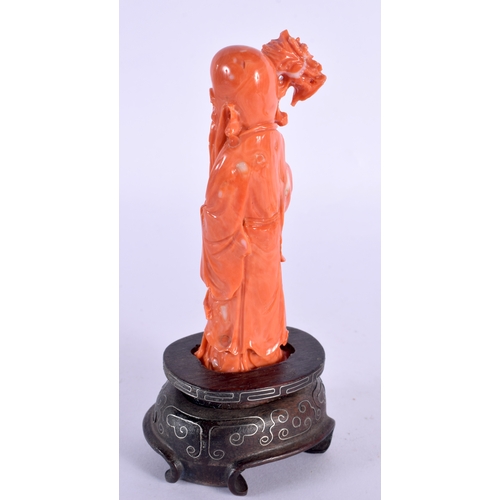 137 - A 19TH CENTURY CHINESE CARVED CORAL FIGURE OF SAGE Qing, modelled holding a dragon sceptre. 15 cm hi... 