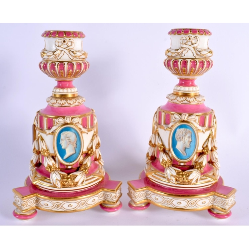 133 - Minton rare pair of candlesticks in Sevres style, painted with busts in medallions on a rose pompado... 