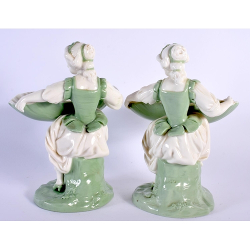 138 - Minton porcelain celadon pair of sweetmeat or bonbon dish figures, depicted as a seated maiden holdi... 