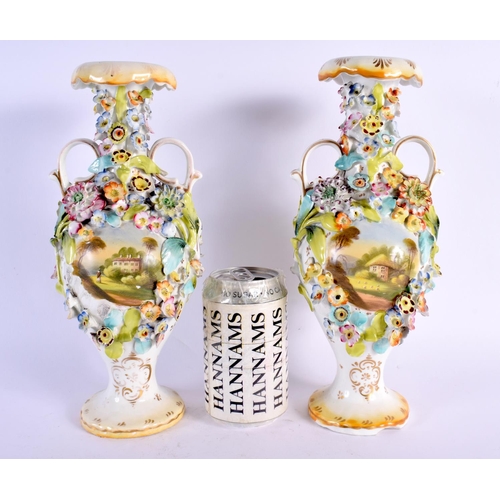 26 - A PAIR OF EARLY 19TH CENTURY ENGLISH TWIN HANDLED VASES painted with buildings. 27 cm high.