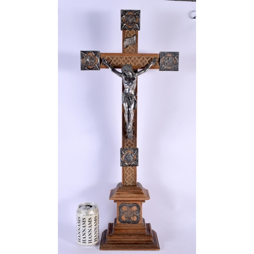 301 - A LARGE 19TH CENTURY EUROPEAN CORPUS CHRISTI CRUCIFIX probably silver, modelled upon an oak plinth. ... 