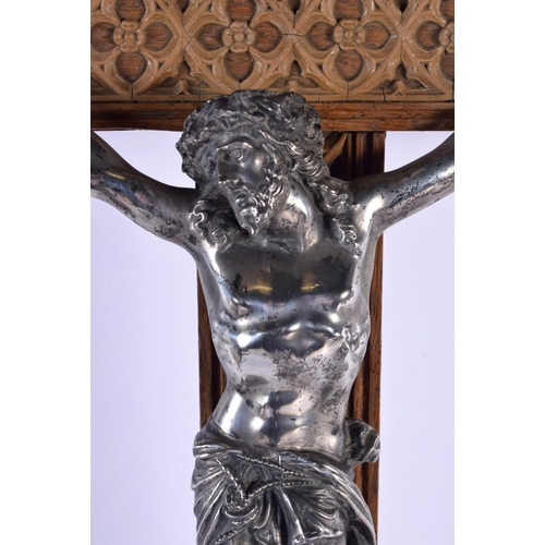 301 - A LARGE 19TH CENTURY EUROPEAN CORPUS CHRISTI CRUCIFIX probably silver, modelled upon an oak plinth. ... 