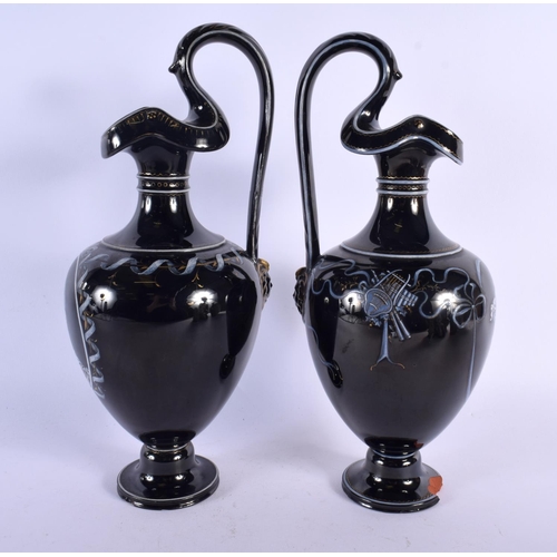 350 - A LARGE PAIR OF MID 19TH CENTURY ENGLISH BLACK POTTERY EWERS painted with portraits. 32 cm high.