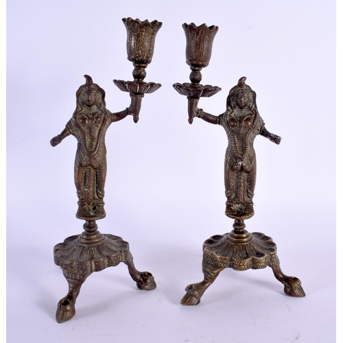 355 - A PAIR OF 19TH CENTURY MIDDLE EASTERN INDIAN BRONZE CANDLESTICKS formed as deities holding aloft sco... 