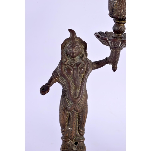 355 - A PAIR OF 19TH CENTURY MIDDLE EASTERN INDIAN BRONZE CANDLESTICKS formed as deities holding aloft sco... 