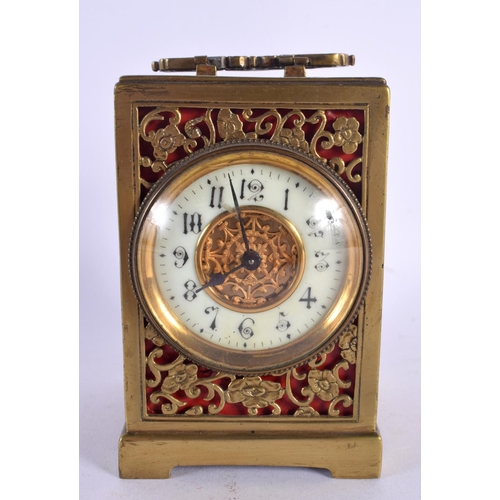 437 - AN ANTIQUE BRASS OPENWORK CARRIAGE CLOCK with circular enamel dial. 16 cm high inc handle.