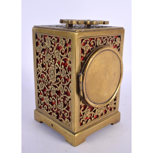 437 - AN ANTIQUE BRASS OPENWORK CARRIAGE CLOCK with circular enamel dial. 16 cm high inc handle.