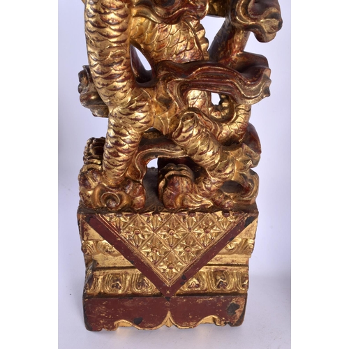 444 - A LARGE PAIR OF 19TH CENTURY SOUTH EAST ASIAN CHINESE PAINTED WOOD DRAGONS modelled upon rectangular... 