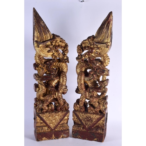 444 - A LARGE PAIR OF 19TH CENTURY SOUTH EAST ASIAN CHINESE PAINTED WOOD DRAGONS modelled upon rectangular... 