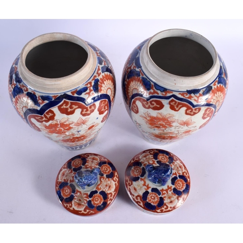 481 - A PAIR OF 19TH CENTURY JAPANESE MEIJI PERIOD IMARI JARS AND COVERS painted with flowers. 32 cm x 12 ... 