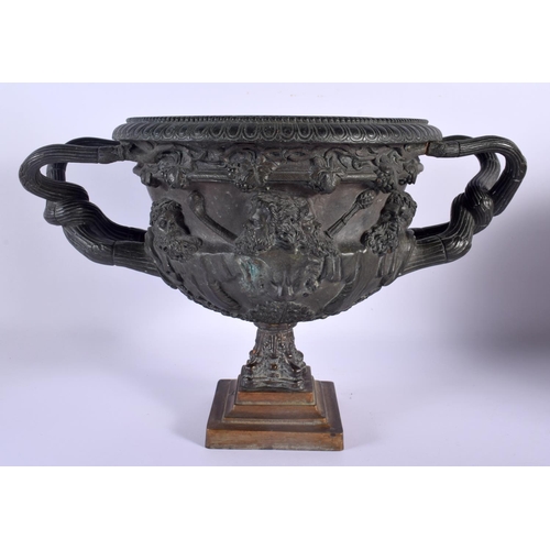 562 - A LARGE 19TH CENTURY BRONZE WARWICK VASE with entwined handles, decorated with classical mask heads.... 