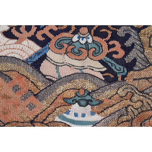 620 - A FINE 18TH CENTURY CHINESE KESI SILK BADGE depicting a bird amongst clouds beside coral coloured su... 