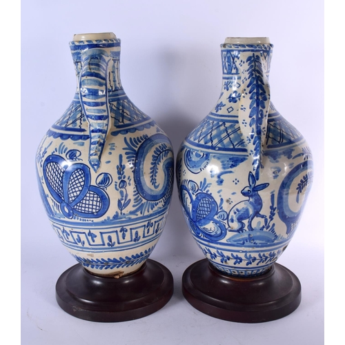 660 - A LARGE PAIR OF 18TH/19TH CENTURY SPANISH TIN GLAZED JUGS painted with deer within landscapes. 44 cm... 