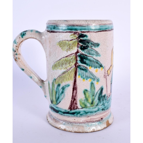 799 - AN 18TH/19TH CENTURY EUROPEAN FAIENCE POTTERY MUG painted with a roaming male. 11 cm high.