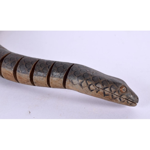 817 - AN UNUSUAL EARLY 20TH CENTURY CONTINENTAL FOLK ART CARVED WOOD SNAKE of articulated form. 80 cm long... 