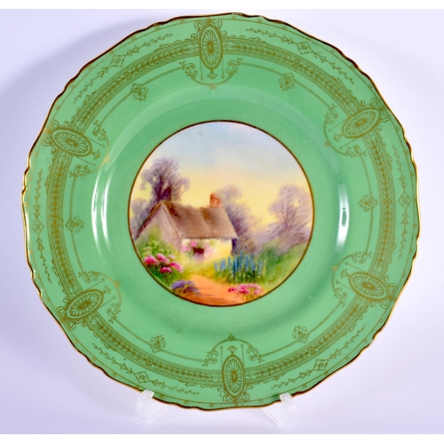 88 - Royal Worcester plate painted with a cottage scene under a green art deco border signed by Raymond R... 