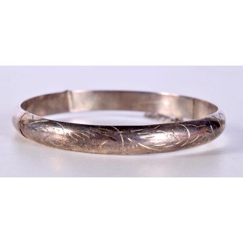 1014 - A SILVER BANGLE together with a Watneys brown ale bottle opener. Largest 14 cm long. (2)